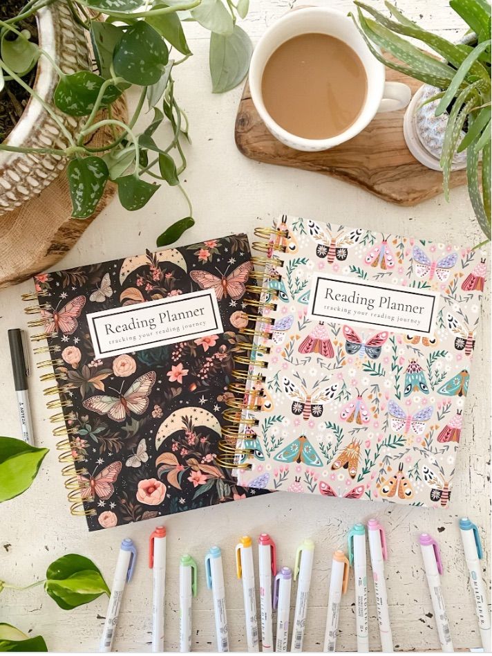 Image of two reading journals beside pens and a cup of coffee.