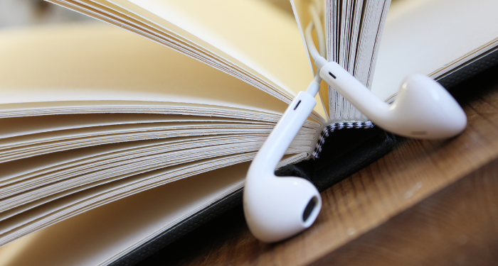 a photo of a book with earbuds being used a bookmark