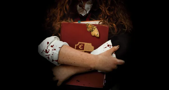 a cropped cover of The Society For Soulless Girls showing someone holding a boarding school binder spattered with blood