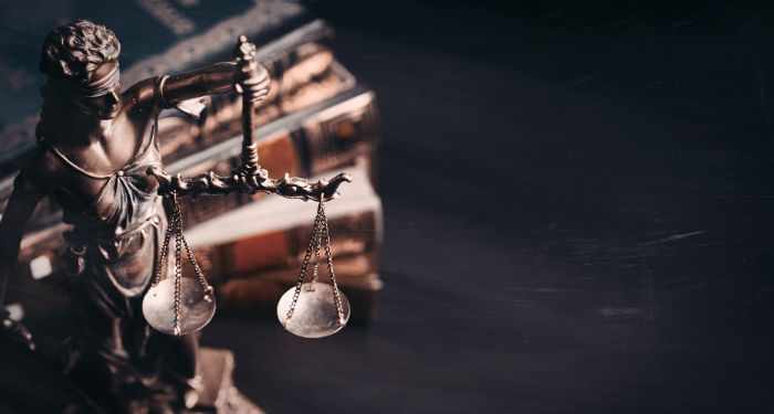 Image of lady justice in front of books