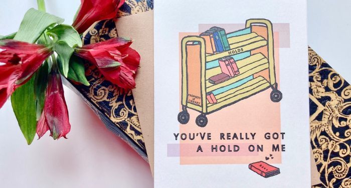 A card depicting a library reserves cart with the words "You've really got a hold on me"