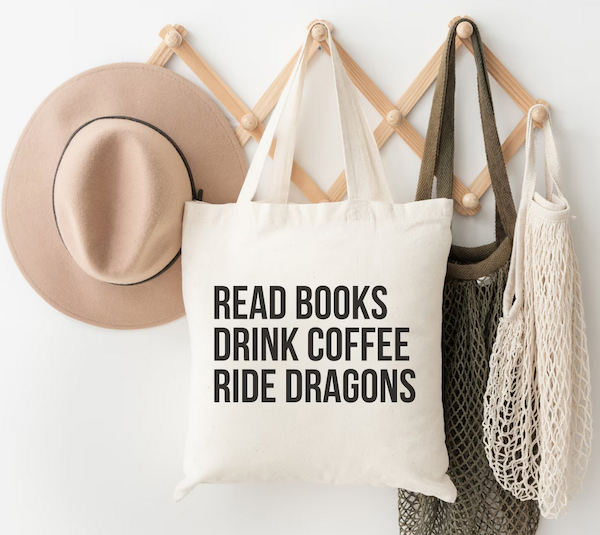 a tote bag with black text that says Read Books Drink Coffee Ride Dragons