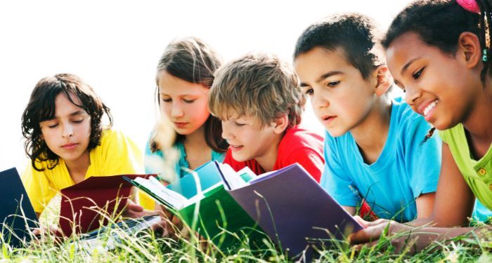 image of children reading in the grass