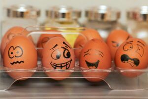 Carton of eggs with faces drawn in sharpie