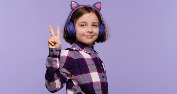 a child wearing cat ear headphones and showing the peace sign