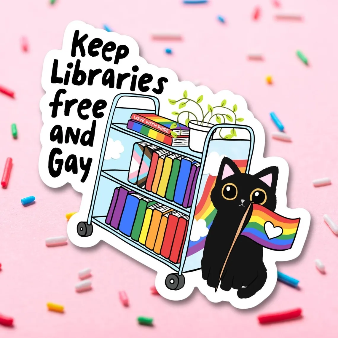 a rainbow book cart sticker with a cat holding a pride flag and the text Keep librararies free and gay