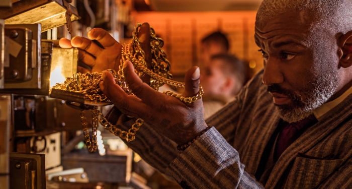 a photo of a vintage bank robbery showing a man removing gold jewelry from a safety deposit box