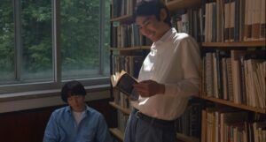 two tan-skinned men of color reading in a library