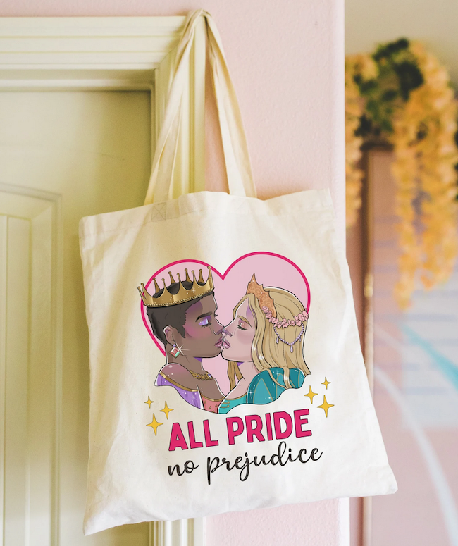 a tote bag with an illustration of two people in crowns kissing inside a heart with text saying All Pride No Prejudice