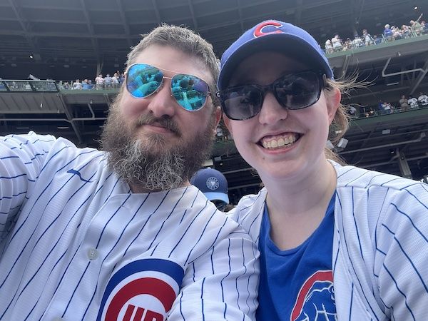 a selfie of a smiling man and woman wearing Cubs jerseys