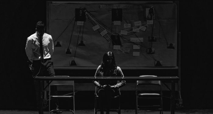 black and white photo of investigators in front of a crime board