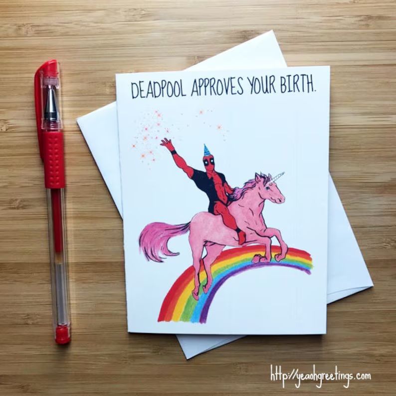 A homemade card with a picture of Deadpool riding a unicorn on a rainbow. Text at the top reads, "Deadpool approves your birth." in all caps.