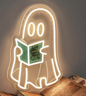 a neon sign of a ghost holding a book and the book cover can be customized