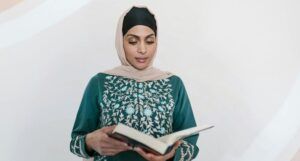 a light brown-skinned woman in a Hijab reading a book