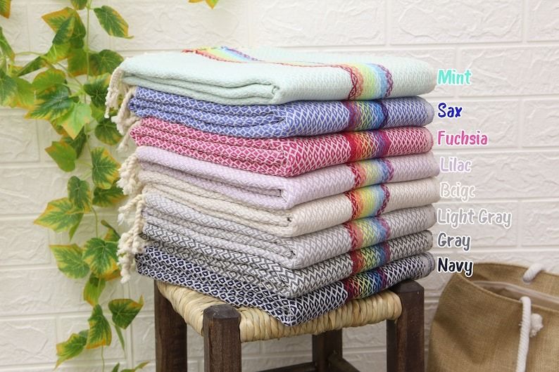 a stack of beach towels with a rainbow stripe