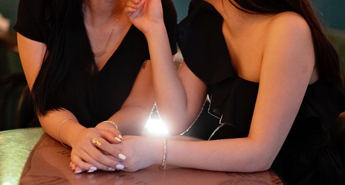 cropped image of two women holding hands