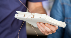 someone sewing pages as part of bookbinding