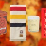 tea tin, wool blanket, candle, and BOOK OF LOVE book cover against blurred backdrop of autumn leaves