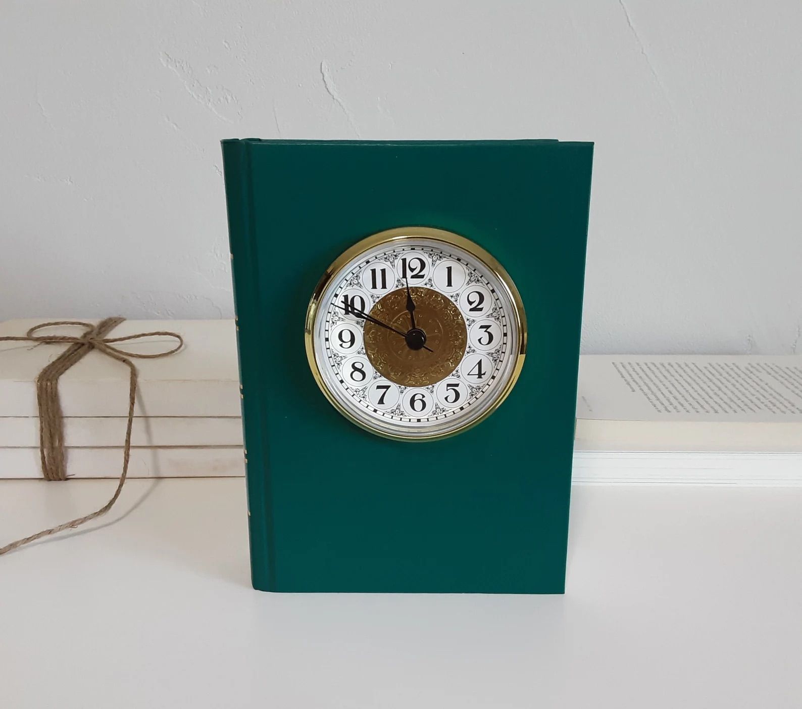 Green book clock on a white counter. 