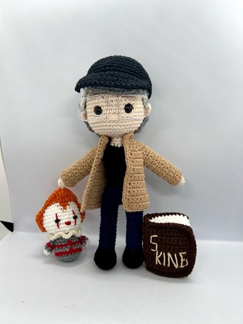 Stephen King crochet doll with IT doll and a small crocheted book.