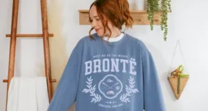 a person wearing a sweatshirt that says Bronte: Meet Me On the Moors