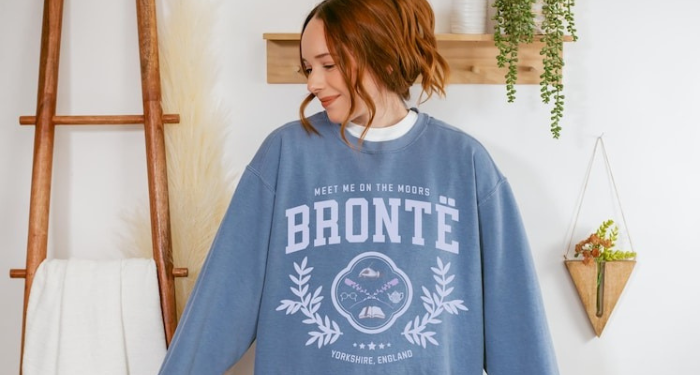 a person wearing a sweatshirt that says Bronte: Meet Me On the Moors