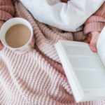 someone reading in bed with a cup of tea