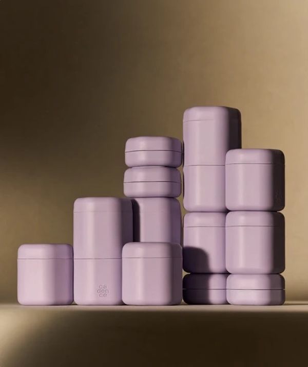 a dozen assorted sizes of lavender-colored toiletry capsules