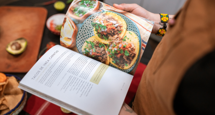 someone reading a cookbook recipe for tacos