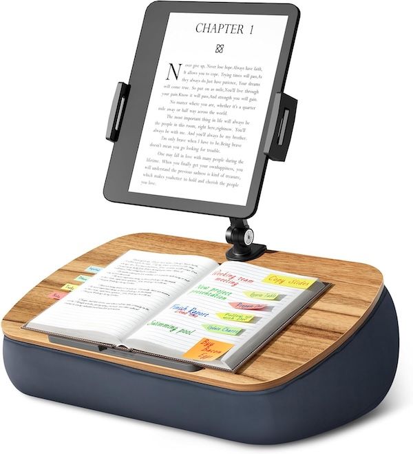 a tablet/ereader stand. The portion that holds the tablet is mounted on a wood surface supported by a pillow base