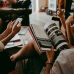 people gathered in a circle with books talking to each other