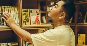 an Asian man looking at books in a bookstore