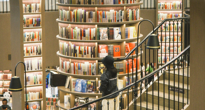 a tall column-shaped bookshelf in the middle of a library