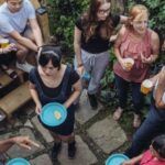 several people of different ages, genders, and races gathered in a backyard patio