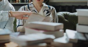 two people looking at books on a desk