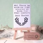 a mini canvas on an easel with a Jane Austen quotation: "Ah! There is nothing like staying at home for real comfort."