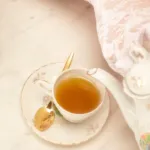 someone wearing lace gloves pouring tea