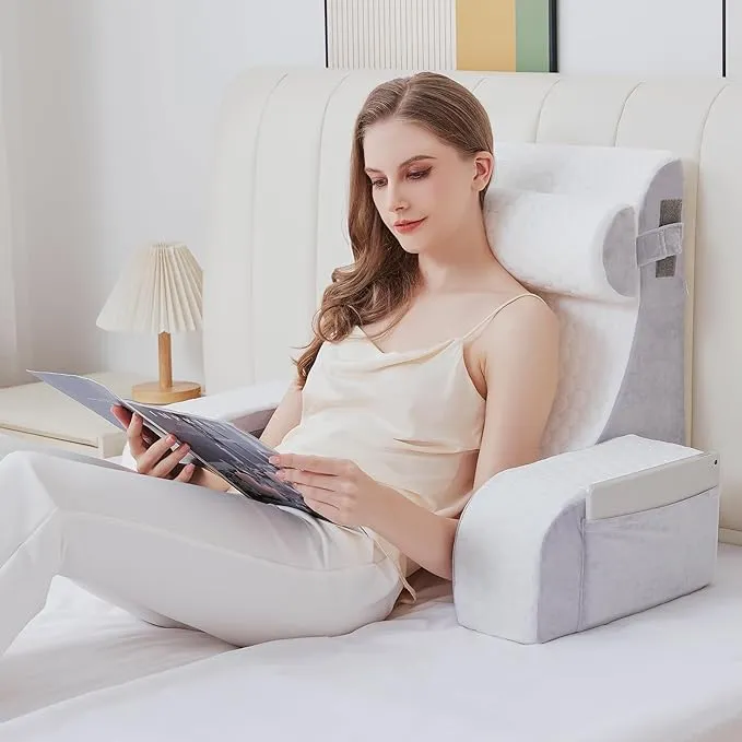 a reading pillow being used in bed that includes arm rests