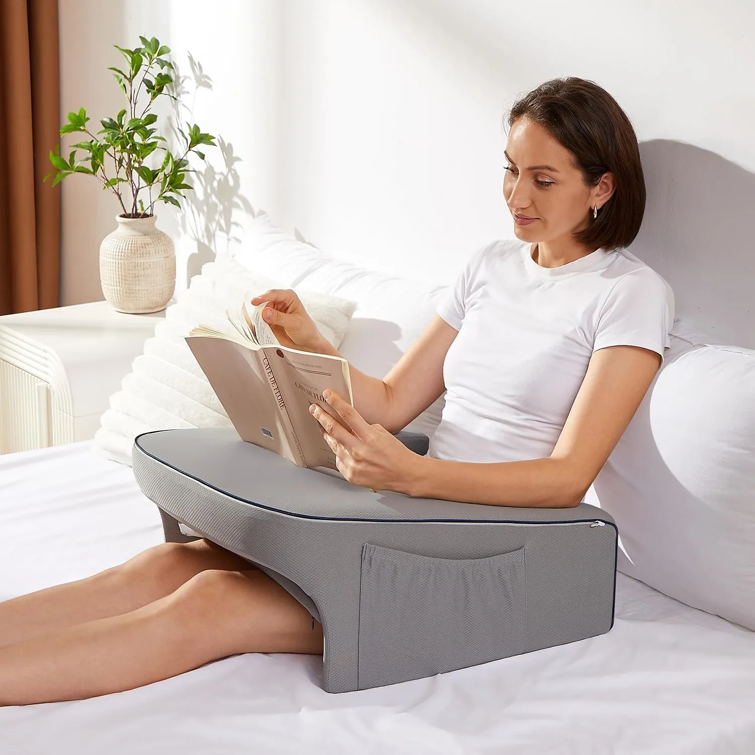 a woman reading using a reading pillow lap desk