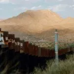 border walls in Mexico against backdrop of mountains and sky