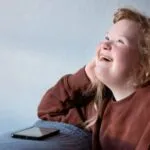 image of a disabled teen with a phone in front of her.