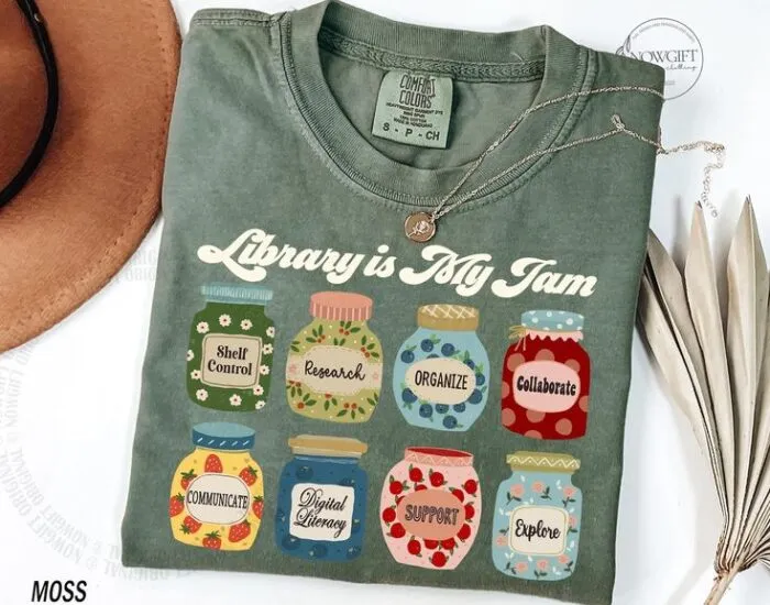 moss-colored t-shirt with white font that reads library is my jam over images of jam jars labeled with aspects of professional librarianism