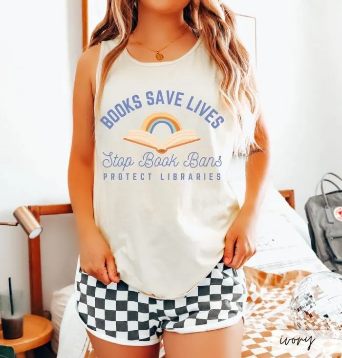 white thank with an image of an open book with a rainbow and text that reads "books save lives, stop book bans, protect libraries"