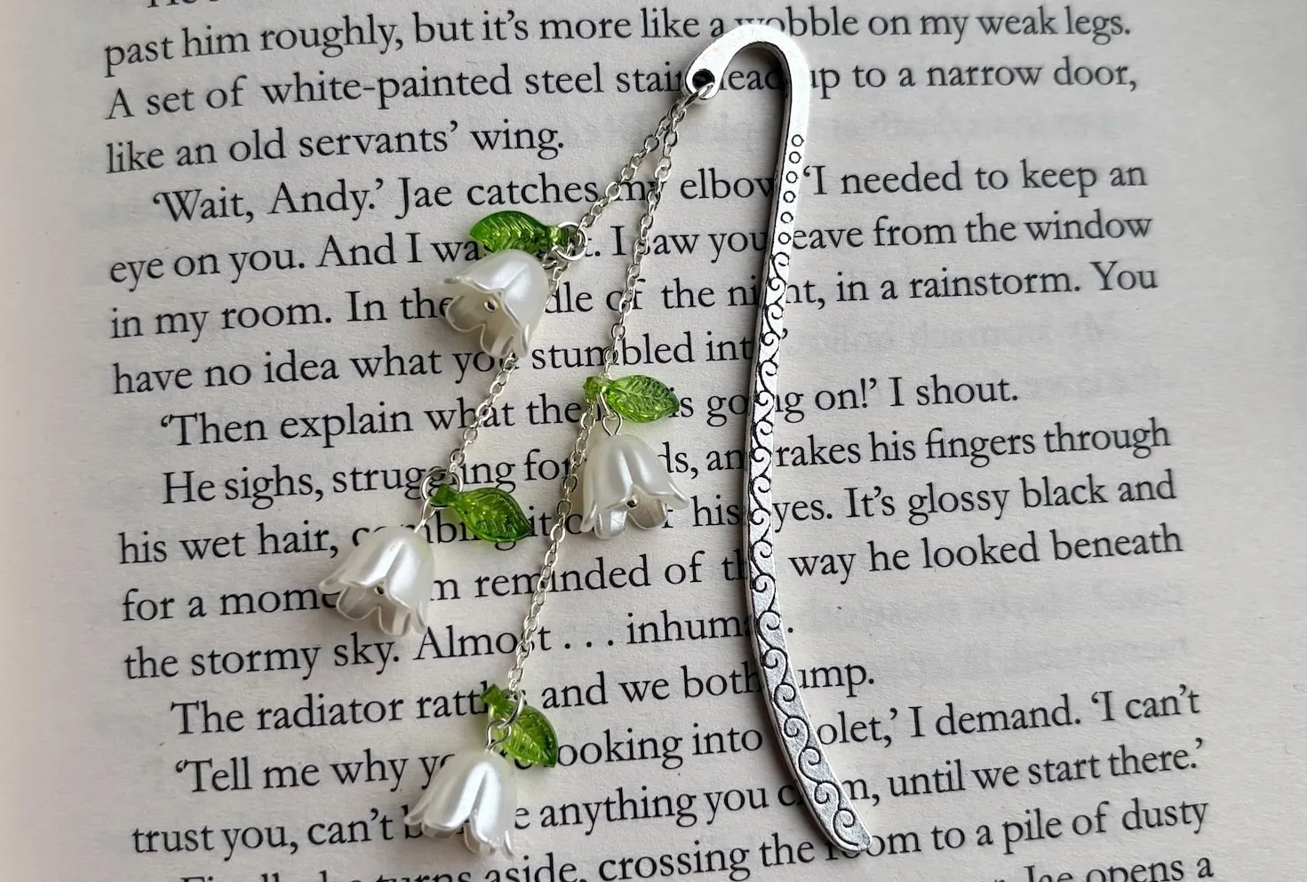 a metal bookmark with floral charms